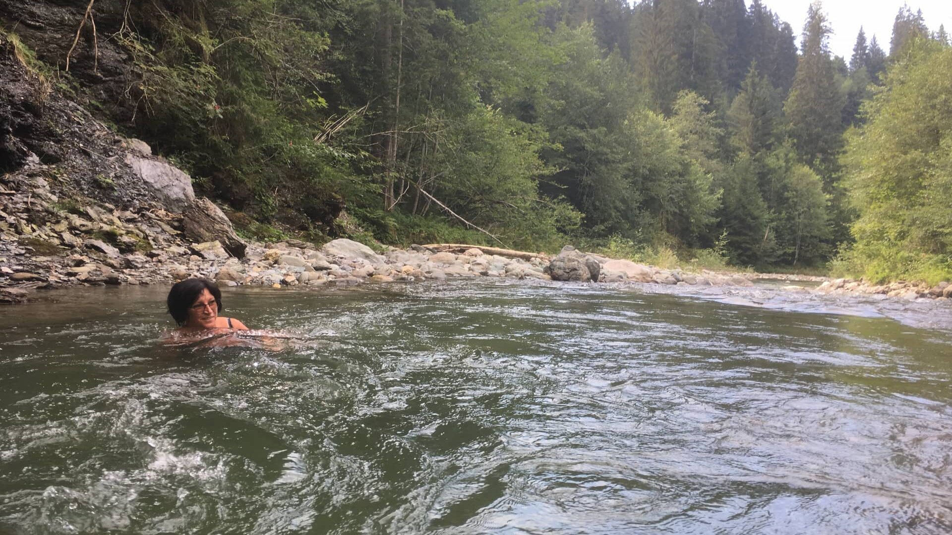 Person schwimmt in einem grünen Fluss.